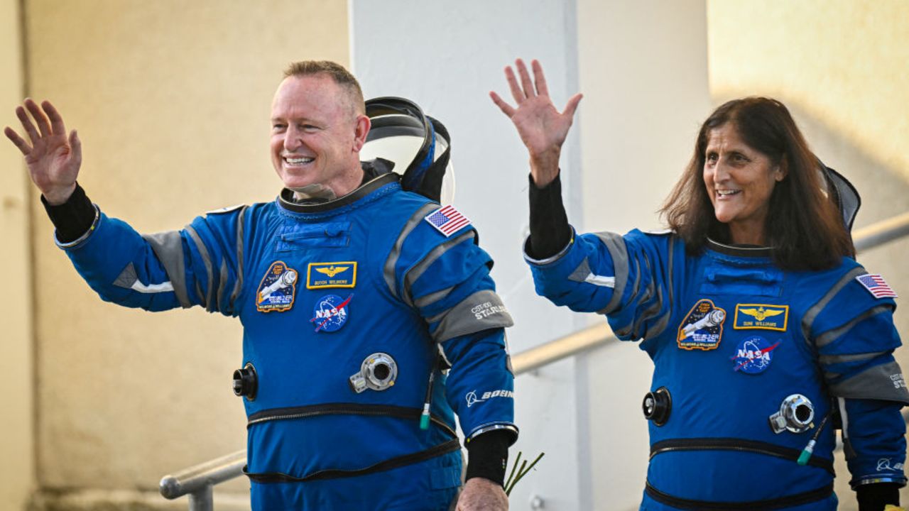 NASA astronauts Butch Wilmore (L) and Suni Williams, wearing Boeing spacesuits, wave as they prepare to depart the Neil A. Armstrong Operations and Checkout Building at Kennedy Space Center for Launch Complex 41 at Cape Canaveral Space Force Station in Florida to board the Boeing CST-100 Starliner spacecraft for the Crew Flight Test launch, on June 5, 2024. Boeing on June 5 will try once more to launch astronauts aboard a Starliner capsule bound for the International Space Station. Liftoff is targeted for 10:52 am (1452 GMT) for a roughly one-week stay at the orbital laboratory. (Photo by Miguel J. Rodriguez Carrillo / AFP) (Photo by MIGUEL J. RODRIGUEZ CARRILLO/AFP via Getty Images)