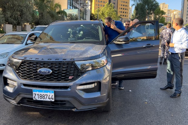 Los agentes de policía inspeccionan un coche en cuyo interior se encuentra un dispositivo de mano...