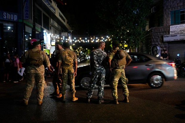 Soldados libaneses hacen guardia en una calle que conduce a...