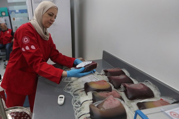 Un voluntario de la Cruz Roja Libanesa recoge donaciones de sangre para aquellos...